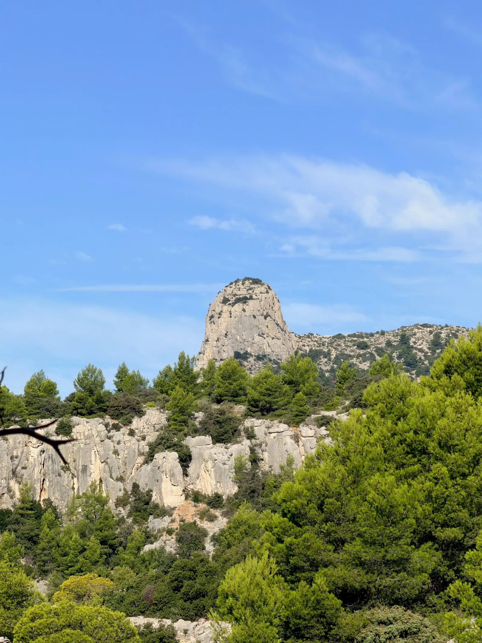 Pointe rocheuse dressée au-dessus de la végétation méditerranéenne.