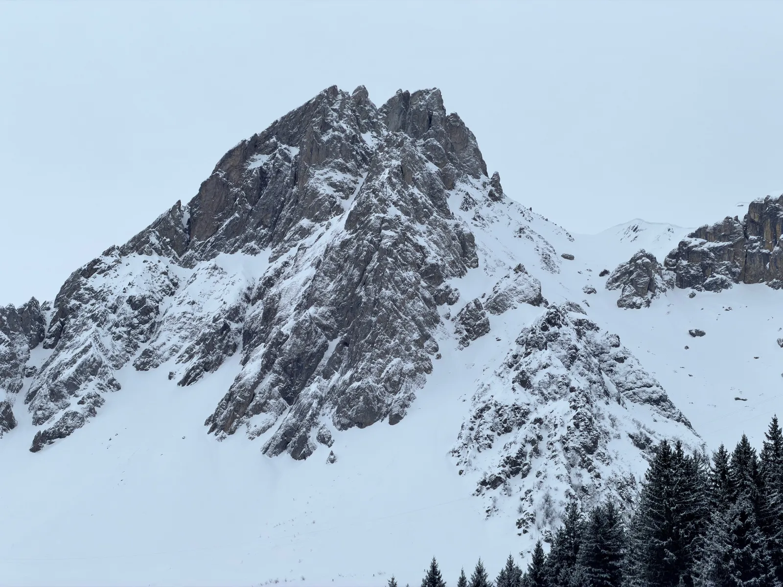 Pointe rocheuse enneigée au-dessus du vallon de montée