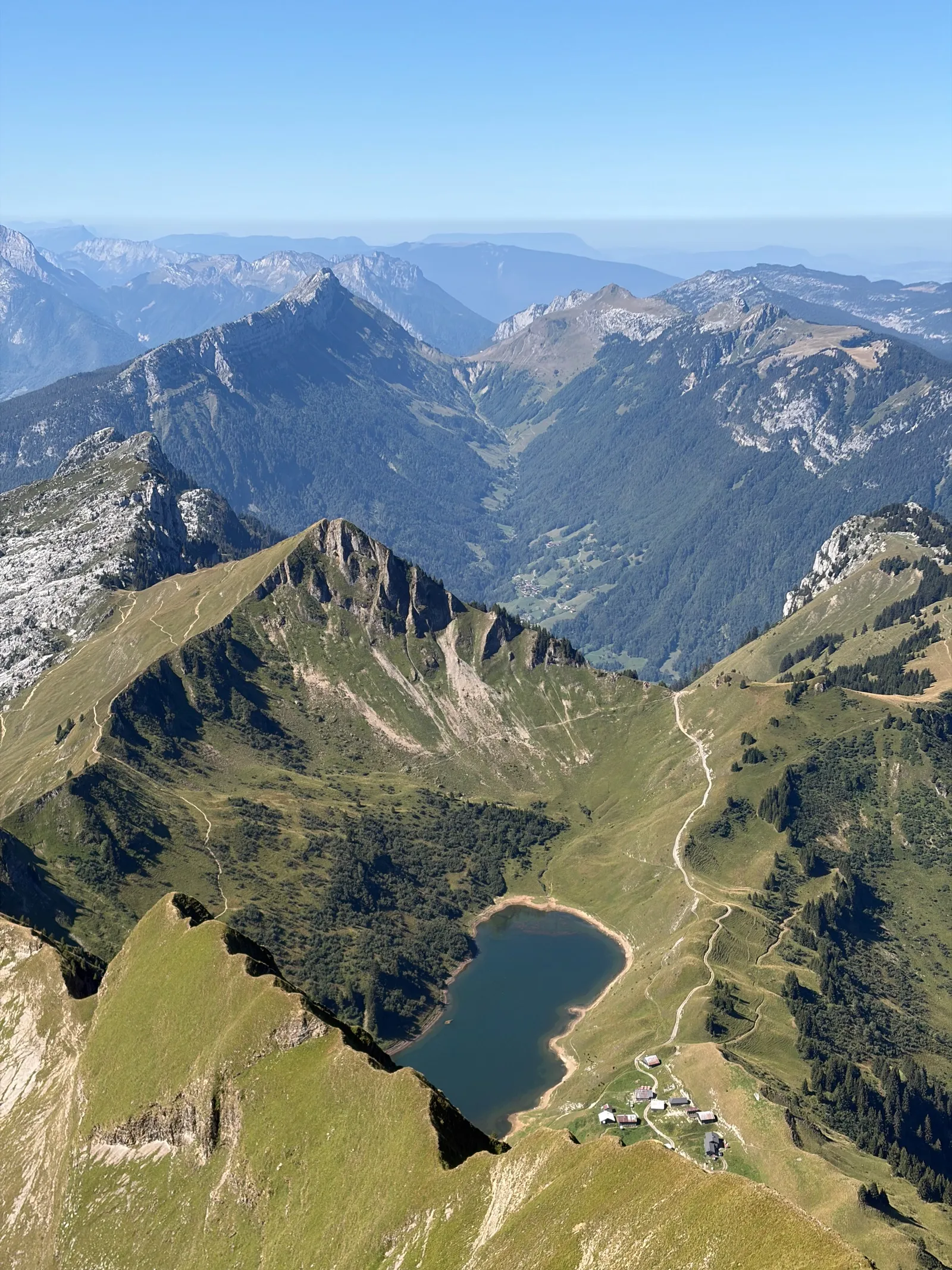 Vue plongeante sur le lac de Lessy, ses chalets et les alpages alentour.