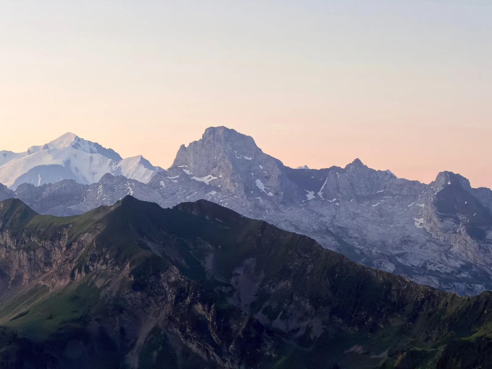 Parois calcaires et Mont-Blanc sous un ciel rosé à l’aube depuis Peyre.