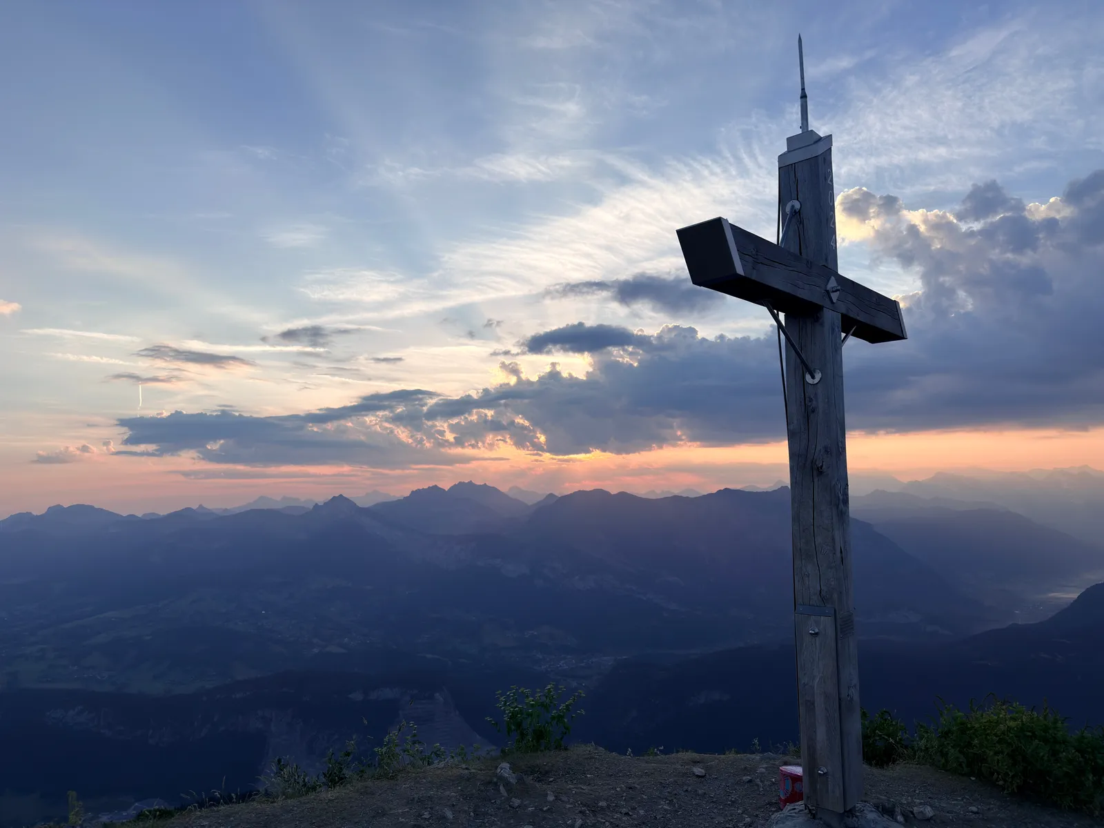 Croix du Môle se détachant devant un ciel lumineux et les montagnes à l’horizon.