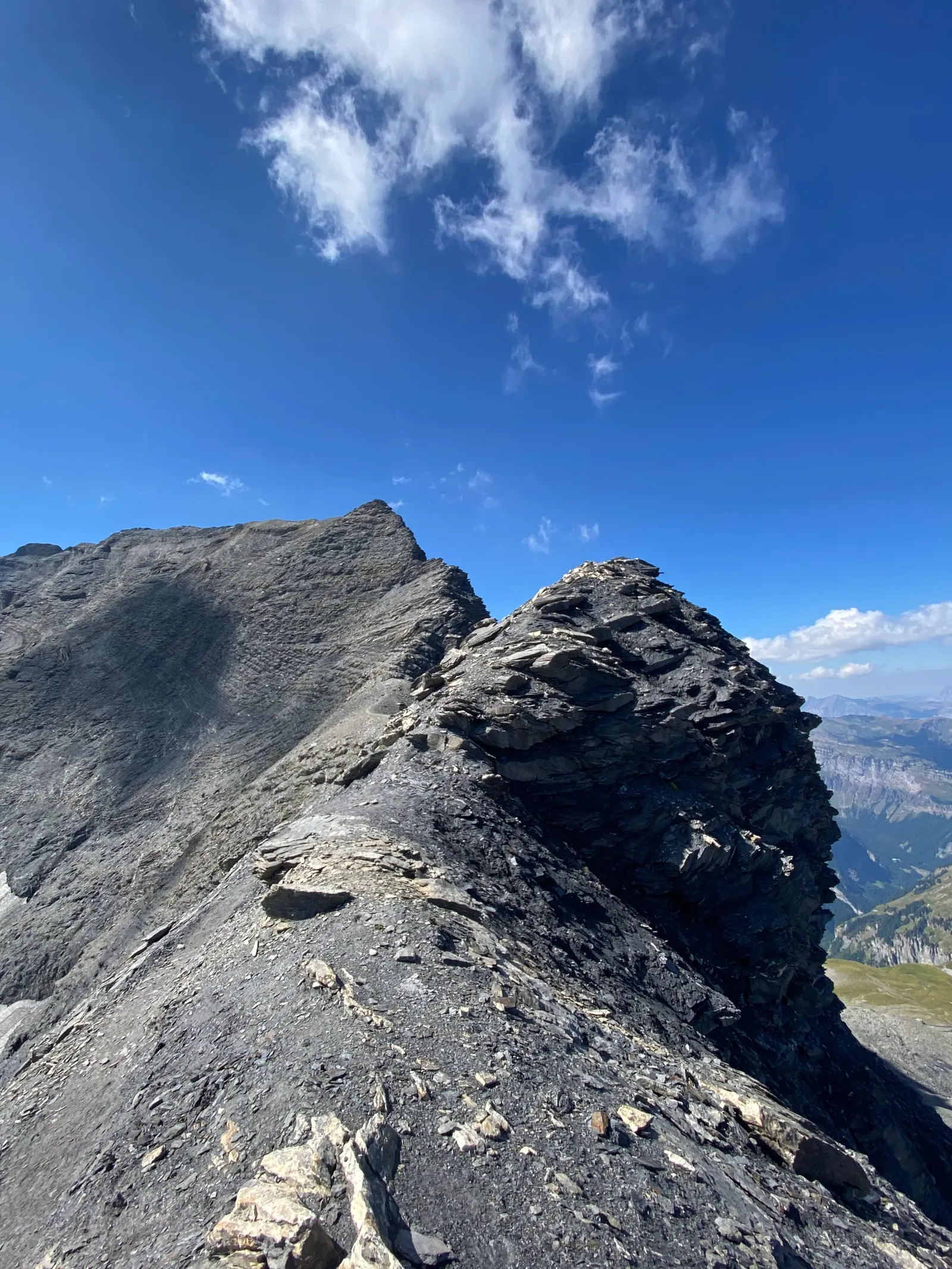 Passage sur une arête rocheuse sous un ciel bleu.