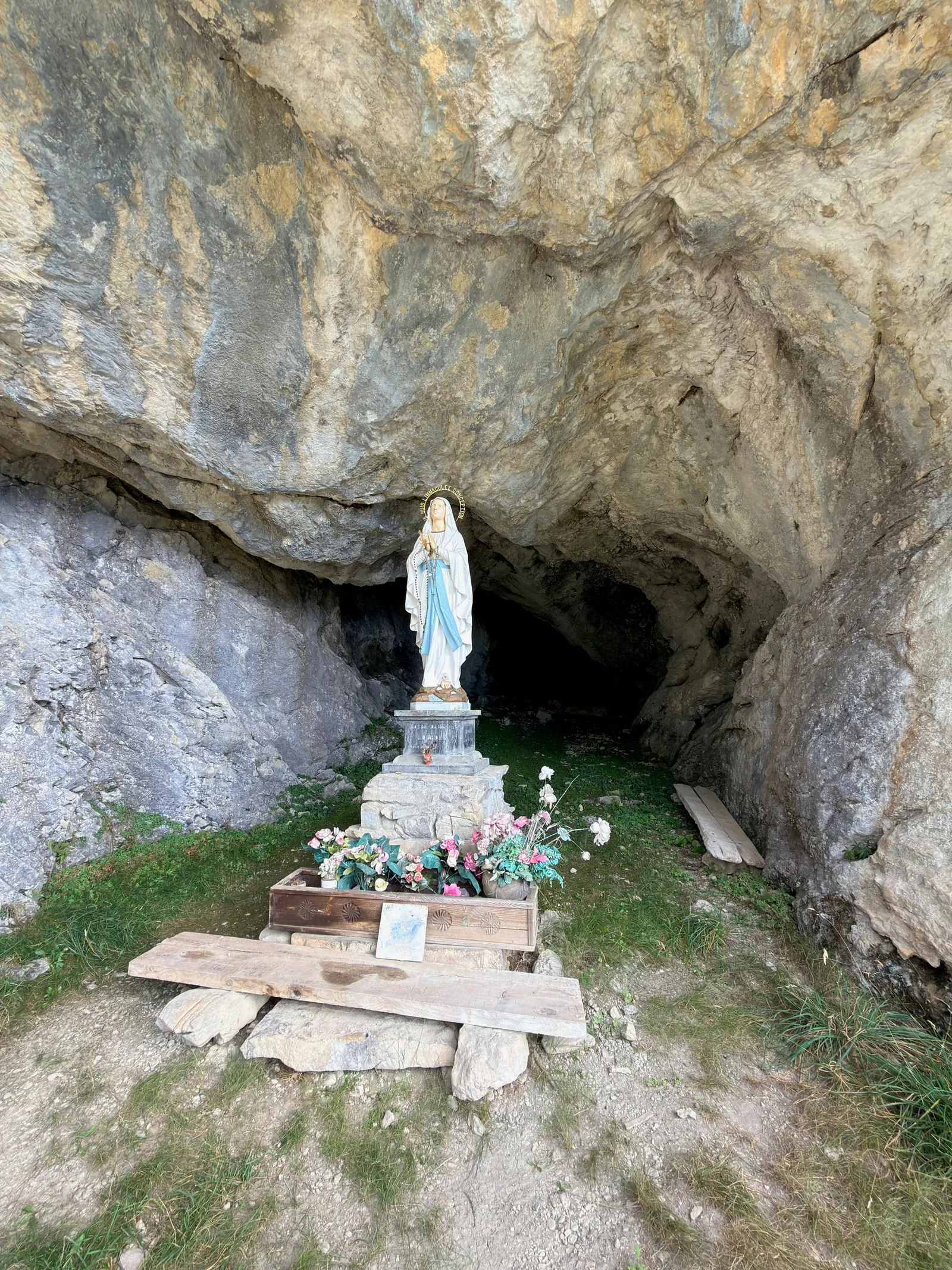 Statue abritée dans une cavité de la paroi rocheuse.