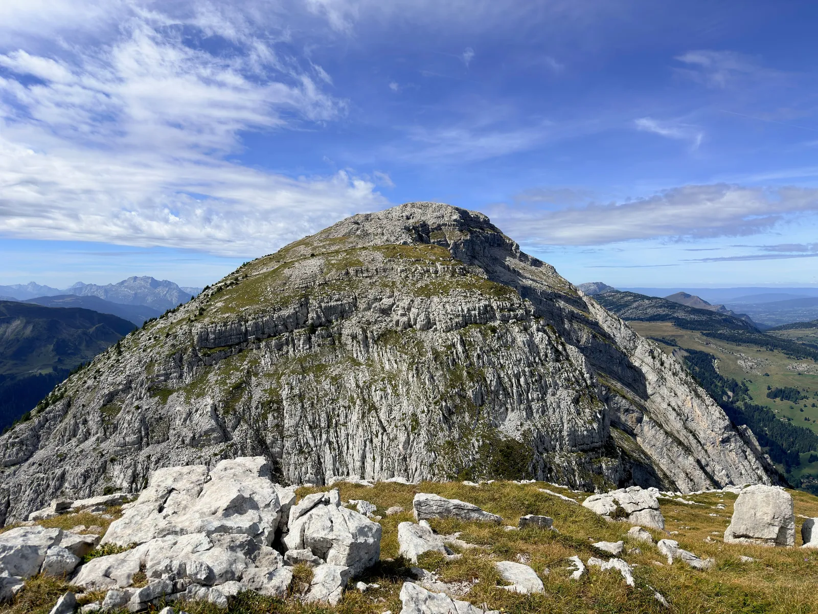 Sommet calcaire aux strates marquées, entouré d’alpages.