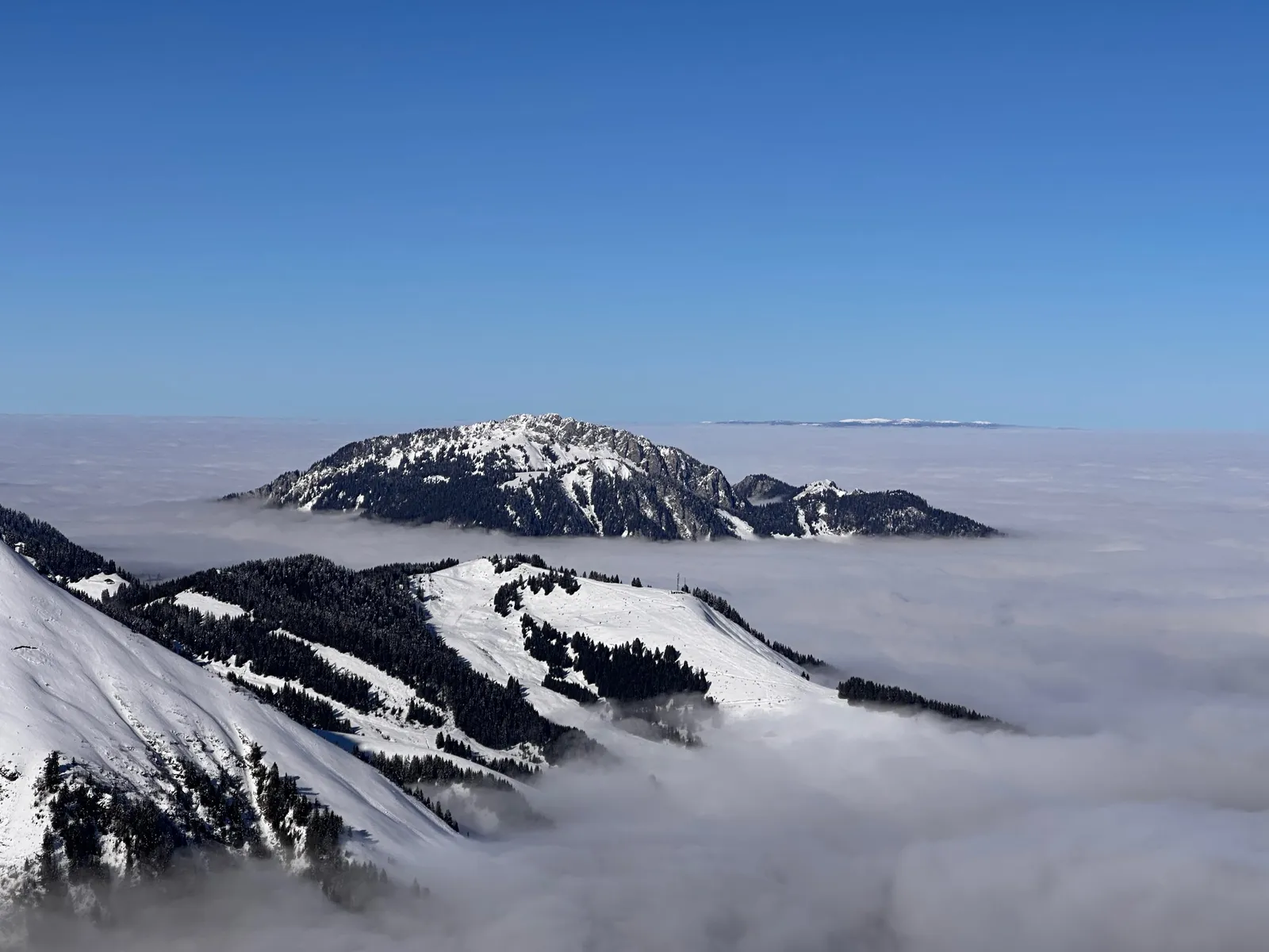 Sommets et versants émergeant d’une mer de nuages.