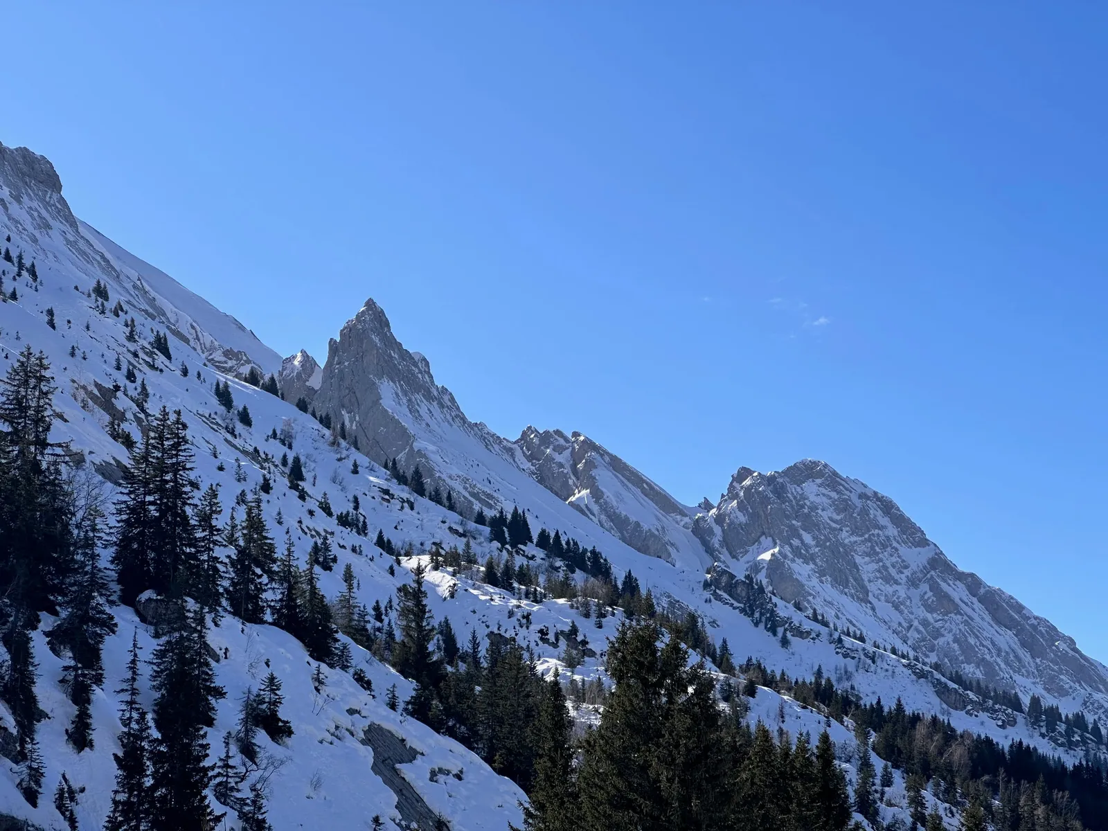 Pointes rocheuses des Aravis au-dessus des pentes enneigées.