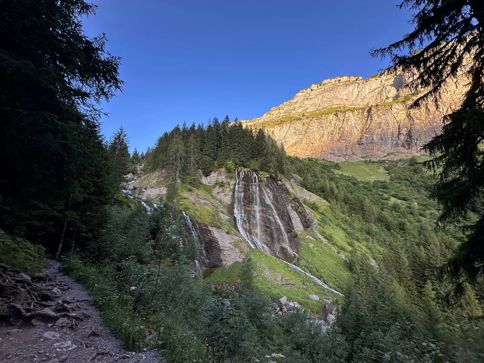 Cascade au pied des falaises des Fiz dans la lumière du matin.